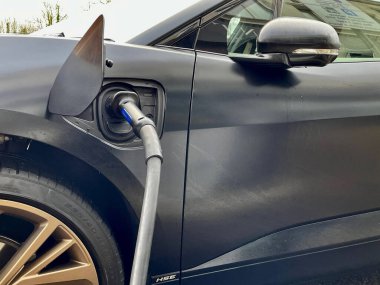 Siyah bir Jaguar elektrikli arabası şarj oluyor.