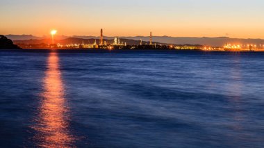 Hawke 's Bay, Yeni Zelanda' daki Ocean Beach 'in güzel bir manzarası. Turuncu güneş maviyi yansıtıyor.