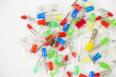 Beyaz arkaplanda öncü ışık renkli lambaların ve elektrik parçalarının üst görünümü