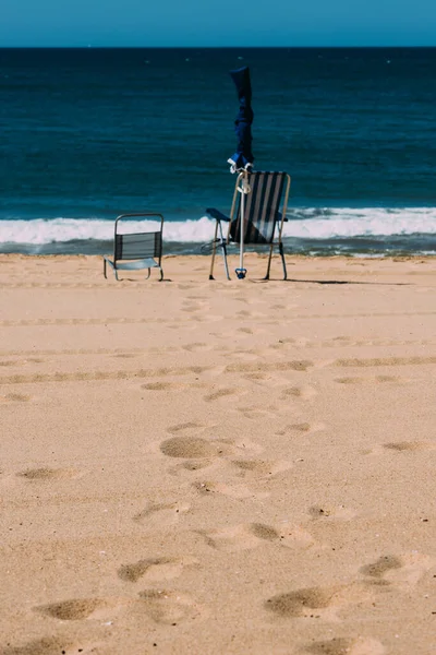 발자국 모래가 해변에 우산을 의자와 포르투갈 알가르베에서 밀려드는 — 스톡 사진