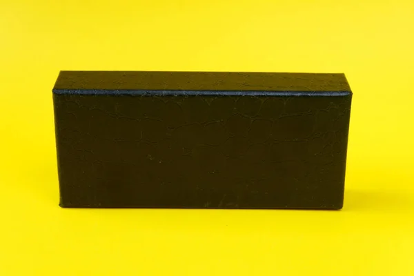 黄色背景的黑色礼品盒特写照片 — 图库照片