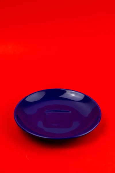 Függőleges Közelkép Egy Kék Csészealjról Piros Háttérrel — Stock Fotó