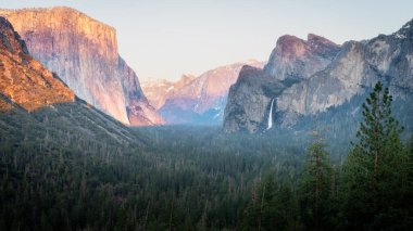 Yosemite Ulusal Parkı, Kaliforniya 'nın dağları ve ormanları üzerindeki günbatımının panoramik görüntüsü