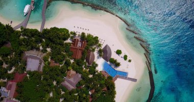 Güneşli bir günde temiz su ve kumlu plajlı güzel bir adanın hava aracı görüntüsü.