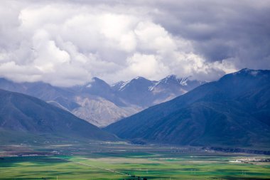 Dağların arka planında güzel bir tarla görüntüsü.