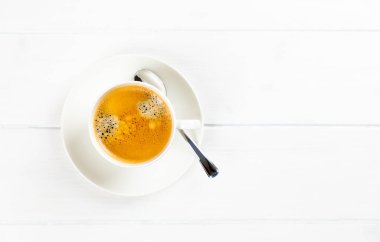 Beyaz ahşap arka planda, fotokopi alanı olan bir kahve bardağının üst görüntüsü.