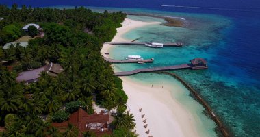 Tropik adanın yakınındaki rıhtımlarda park etmiş yatların kuş bakışı görüntüsü.