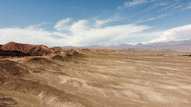 Güneşli bir günde dağlarla kaplı ıssız bir arazinin kuş bakışı görüntüsü.