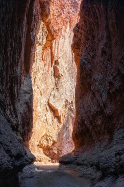 Üzerinde güneş ışığı olan uzun ve büyük bir uçurumun dikey görüntüsü.