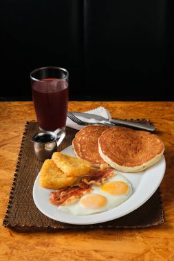 Krep, pastırma, yumurta ve sığır etiyle yapılan bir Amerikan kahvaltısının dikey yakın çekimi.