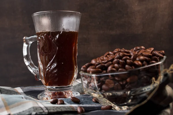 茶色の背景にコーヒー豆と香り高いコーヒーカップ — ストック写真