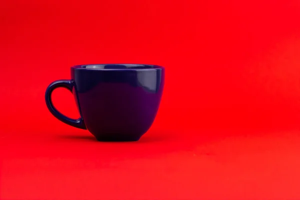Una Toma Lateral Una Taza Azul Oscuro Sobre Fondo Rojo —  Fotos de Stock