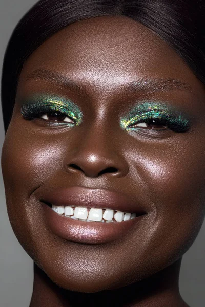 A vertical close-up shot of an Australian black model\'s face in gorgeous make-up.