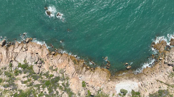 Komodo Adası 'nın yeşil kayalık sahilinin ve açık denizin insansız hava aracı görüntüsü.