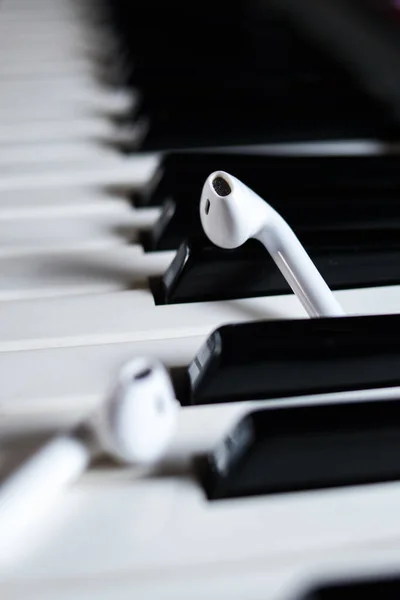 Vertical Closeup Wireless Earphones Black White Piano Keys — Stock Photo, Image