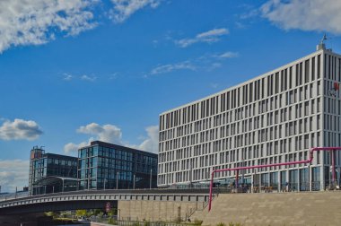 Berlin, Almanya 'daki bulutlu gökyüzüne karşı gündüz vakti Spree Nehri üzerindeki modern binaların güzel bir görüntüsü.