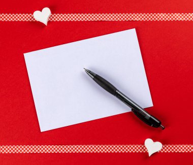 Sevgililer günü için bir aşk mektubu yazmak ve uzayı kopyalamak için kırmızı arkaplan ve kalplere sahip bir üst görünüm