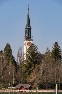 Mavi gökyüzünün altında saatli bir kilise kulesi manzarası