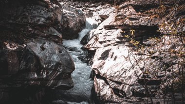 Güneşin altındaki kayalık uçurumlar arasındaki nehrin manzarası.