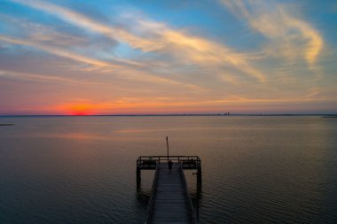 Mobile Körfezi, Alabama, ABD 'nin sakin sularına yansıyan bulutlu bir gün batımı