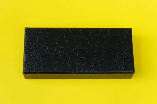 黄色の背景を持つレザーブラックボックス — ストック写真