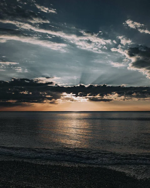 海の上に輝く夕日の空の垂直ショット — ストック写真