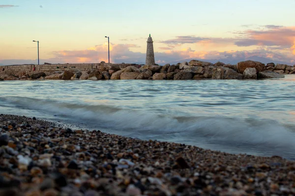 Yakınlarda Deniz Feneri Olan Kayalık Bir Sahilde Gün Batımı Manzarası — Stok fotoğraf