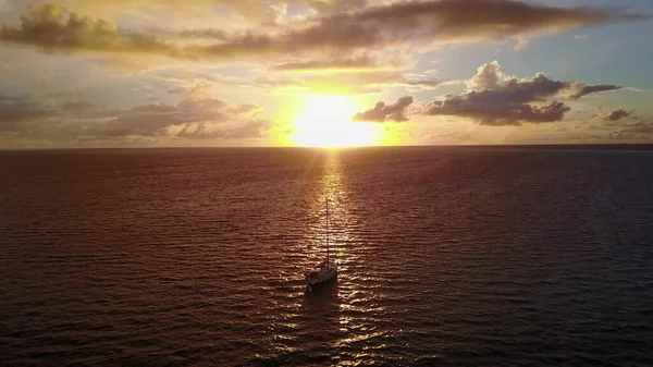 Maldivler 'deki güzel günbatımında okyanusta yelken açan bir tekne.