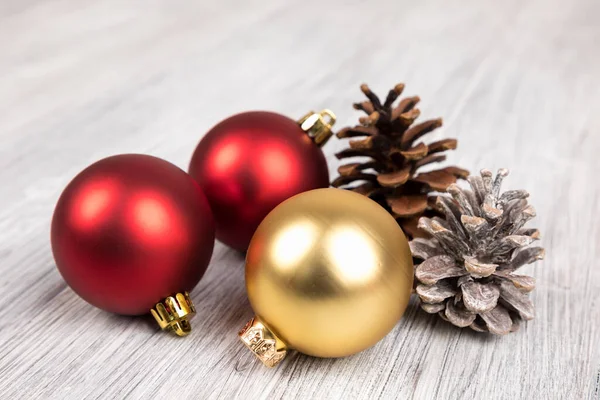 Closeup Red Gold Christmas Tree Ornaments Pinecones Wooden Surface — Stock Photo, Image