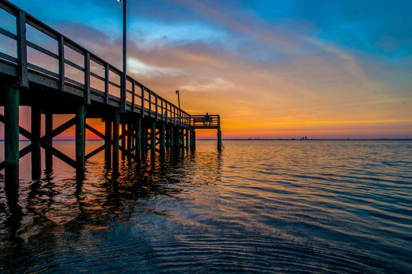 在美国阿拉巴马州莫比尔湾平静的海水中反射出一片多云的落日 — 图库照片
