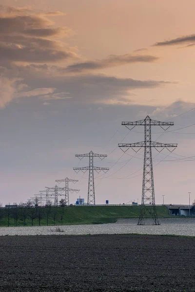 オランダの工業地帯に向かって高速道路を行く送電線の垂直方向 — ストック写真