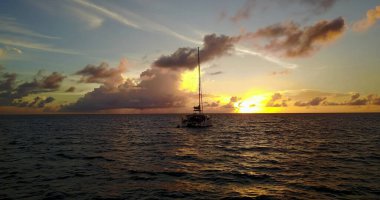Gün batımında bulutlu gökyüzünün altında güzel bir tekne manzarası.