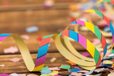 Bulanık ahşap arka planda bir sürü renkli konfeti ve flama