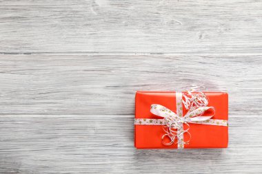 Ahşap bir masada renkli bir noel hediyesi.