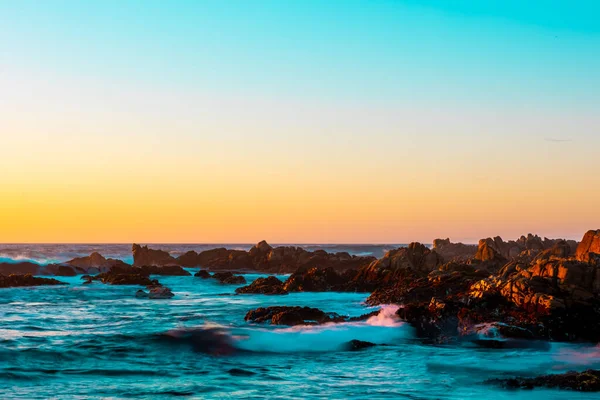 Uma Vista Panorâmica Oceano Rochas Céu Colorido Quente Durante Pôr — Fotografia de Stock