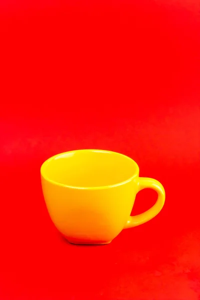 Вертикальный Угловой Снимок Керамической Желтой Чашки Пластину Красном Фоне — стоковое фото