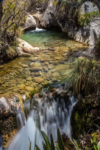 在明亮的阳光下 一个小池塘和山上瀑布的美丽风景 — 图库照片