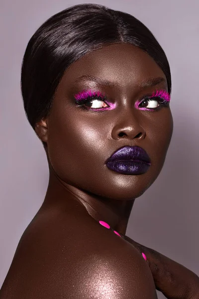 A vertical close-up shot of an Australian black model\'s face in gorgeous make-up.