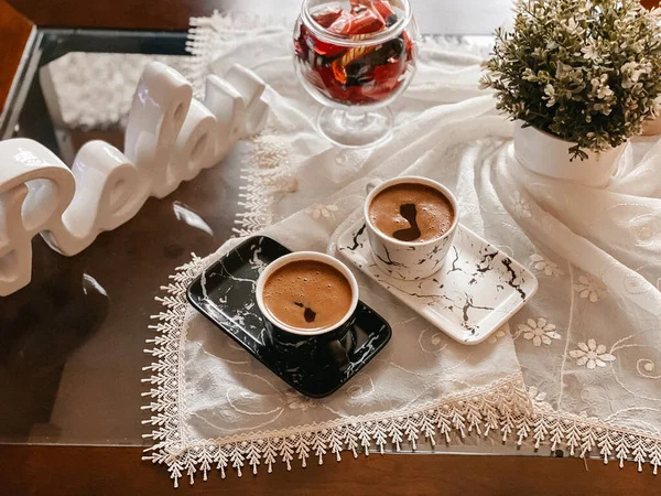 花で飾られたテーブルクロスに美しく配置されたコーヒーカップのトップビュー — ストック写真