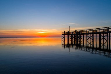 Mobile Körfezi, Alabama, ABD 'nin sakin sularına yansıyan bulutlu bir gün batımı