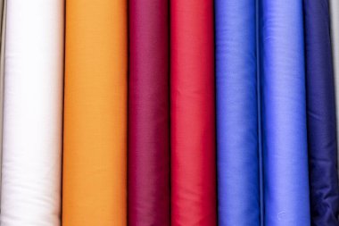 Bir terzinin gömleklerini dikmek için parlak renkli kumaş cıvataları.