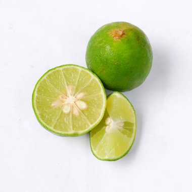 Beyaz arka planda dilimlenmiş kireç parçalarının yakın plan çekimi..