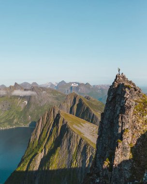 Norveç, Senja 'da kıyı kayalıkları açık mavi gökyüzüne karşı