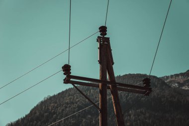 Tepelerin yakınındaki elektrik direğinin alçak açılı görüntüsü.