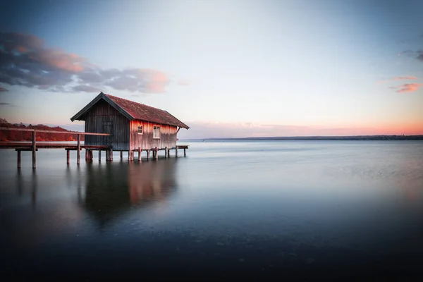 ドイツのバイエルン州の夕日の空に対するアメリカの湖の上のボートハウスの美しい景色 — ストック写真