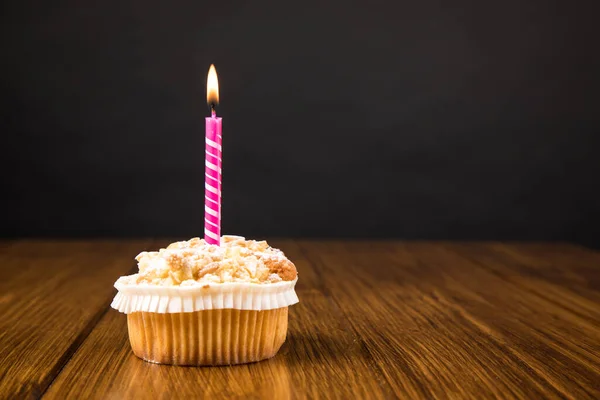 Ein Muffin Mit Brennender Kerze Auf Einem Holztisch Neben Grauer — Stockfoto