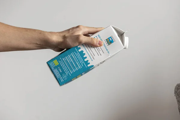 Closeup Hand Holding Fresh Packaged Milk White Wall Advertisement — Stock Photo, Image