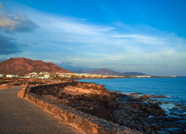 Deniz ve dağ manzaralı bir şehir manzarası