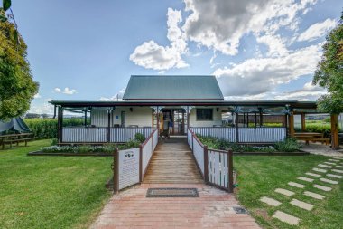 Şarabın üzerindeki mavi gökyüzü baharda yeşil bahçeli bir bölge oluşturuyor.