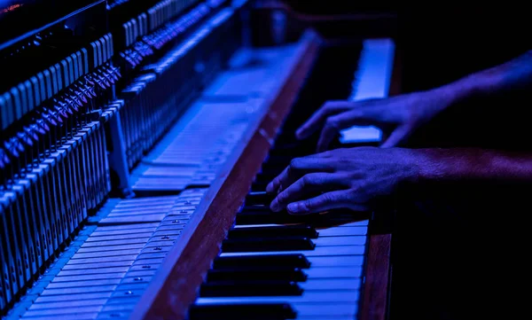 Male pianist playing on a wooden piano